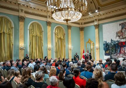 The Governor General is standing at a podium in the ballroom at Rideau Hall.