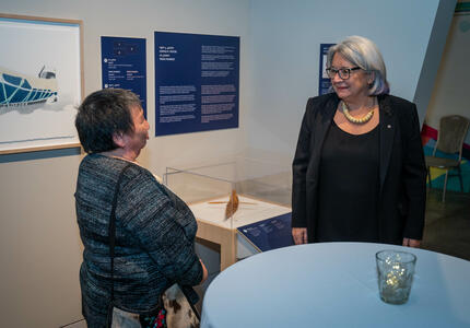 The Governor General is speaking with a woman at the Our Land, Our Art exhibition. 