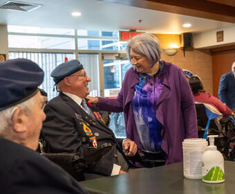 Governor General Mary Simon speaks with an Royal Canadian Air Force Veteran who sits in a wheelchair